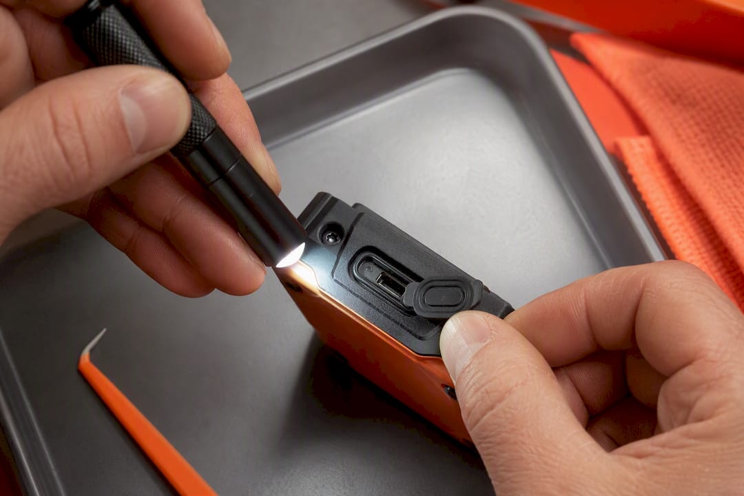 Technician inspecting tracker port cover seal