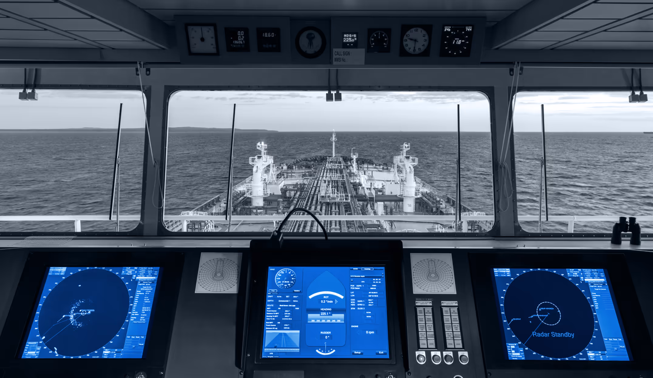 Modern ship bridge with radar screens and navigation systems overlooking the open sea.