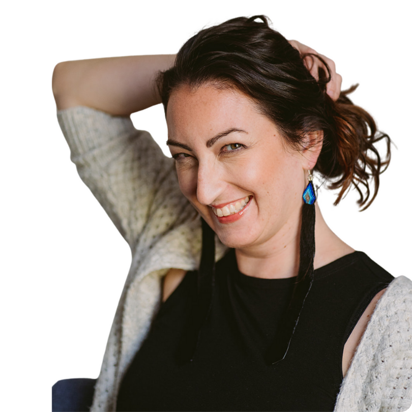 Alison Butler in front of a white background holding her hair up and smiling at the camera