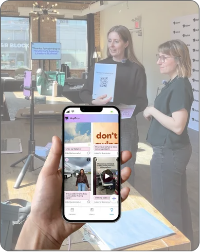 Candid shot of HeyOrca team standing in front of a tripod creating social media content overlaid by a hand holding a smartphone showing HeyOrca's Inspo Library on the screen. 