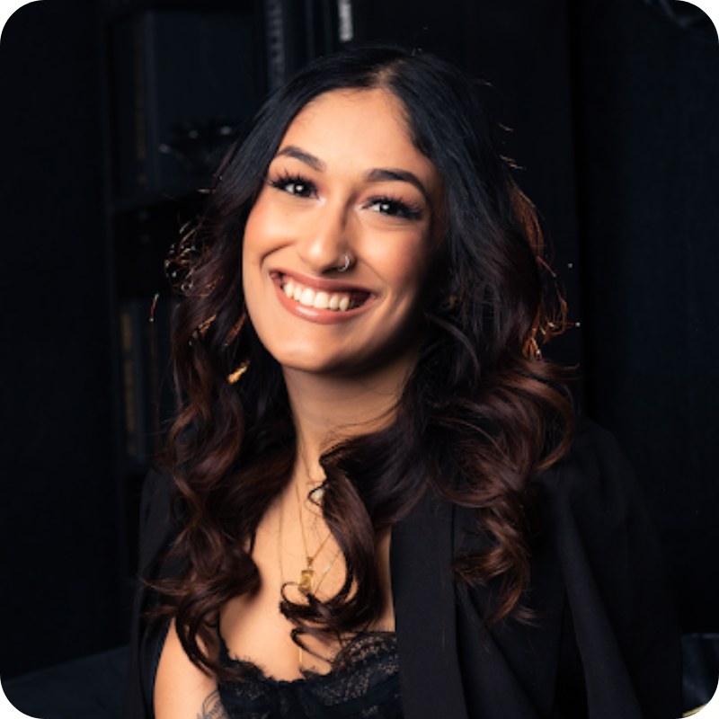 A woman with dark wavy hair smiles brightly for the camera.