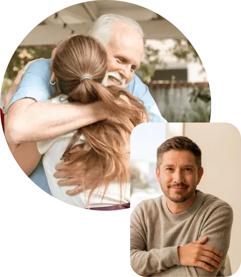 Older man with white hair smiling warmly while hugging a woman with long brown hair, and a young man with short dark hair and a beard sitting with folded arms and smiling softly.