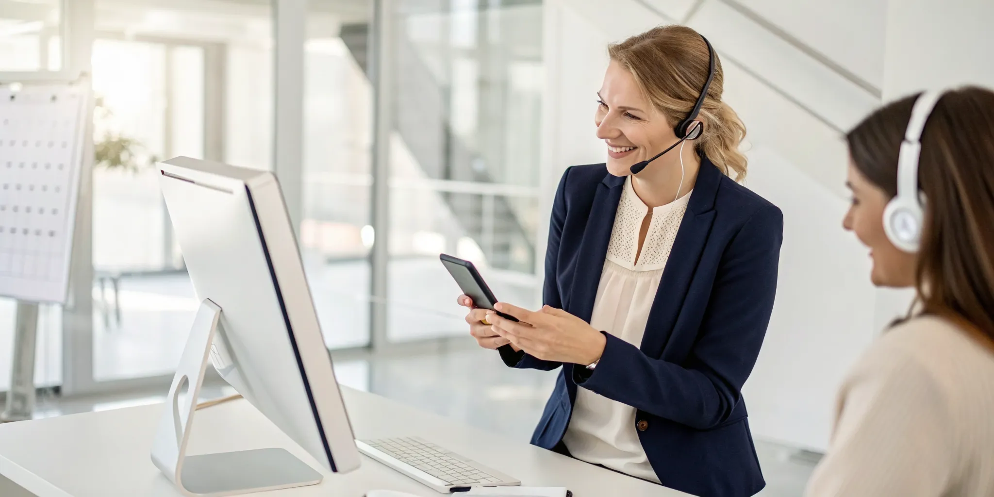 Patient advocates with headsets help with scheduling a doctor appointment on a computer and phone.
