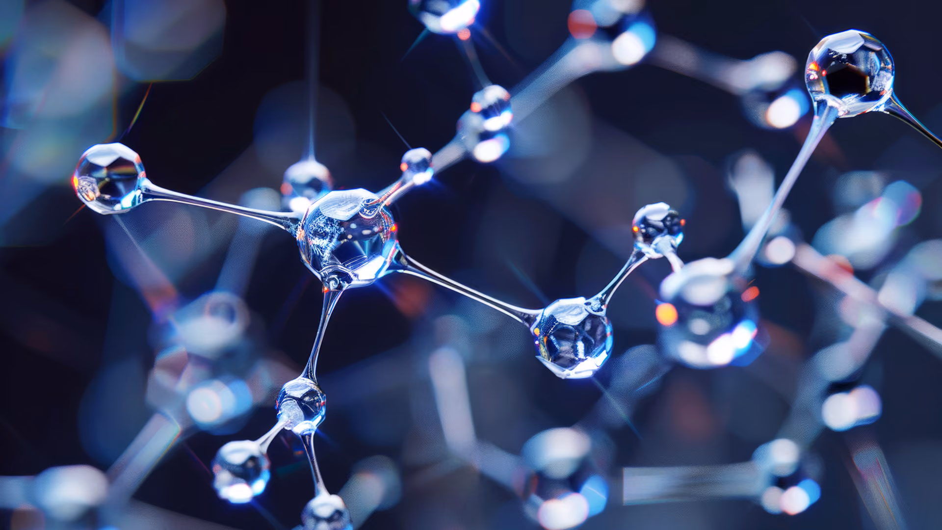 Close-up of transparent, glass-like molecular structures interconnected by thin rods on dark background.