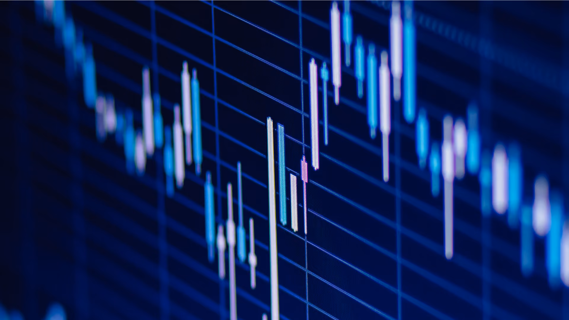 Close-up of a digital candlestick chart showing financial market price movements on dark blue grid.