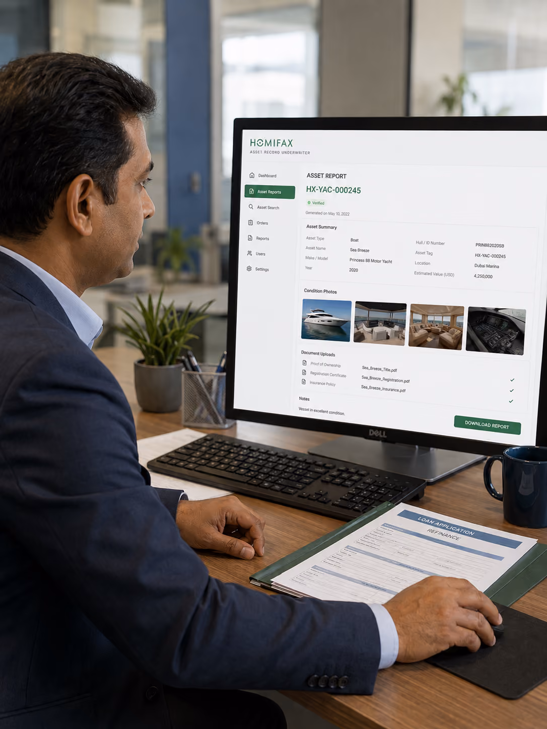 Man in suit reviewing an asset report of a yacht on a computer in an office setting.