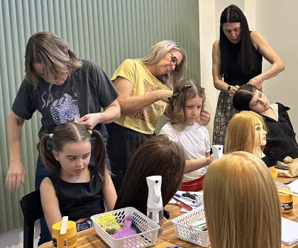 an image showing a group of parents learning to braid at a workshop.