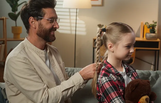 A dad braiding daughter's hair