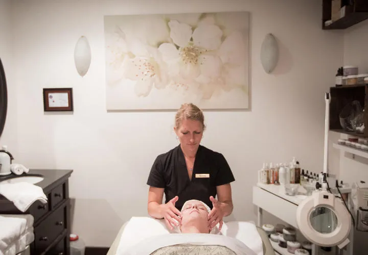 Esthetician giving client a relaxing facial
