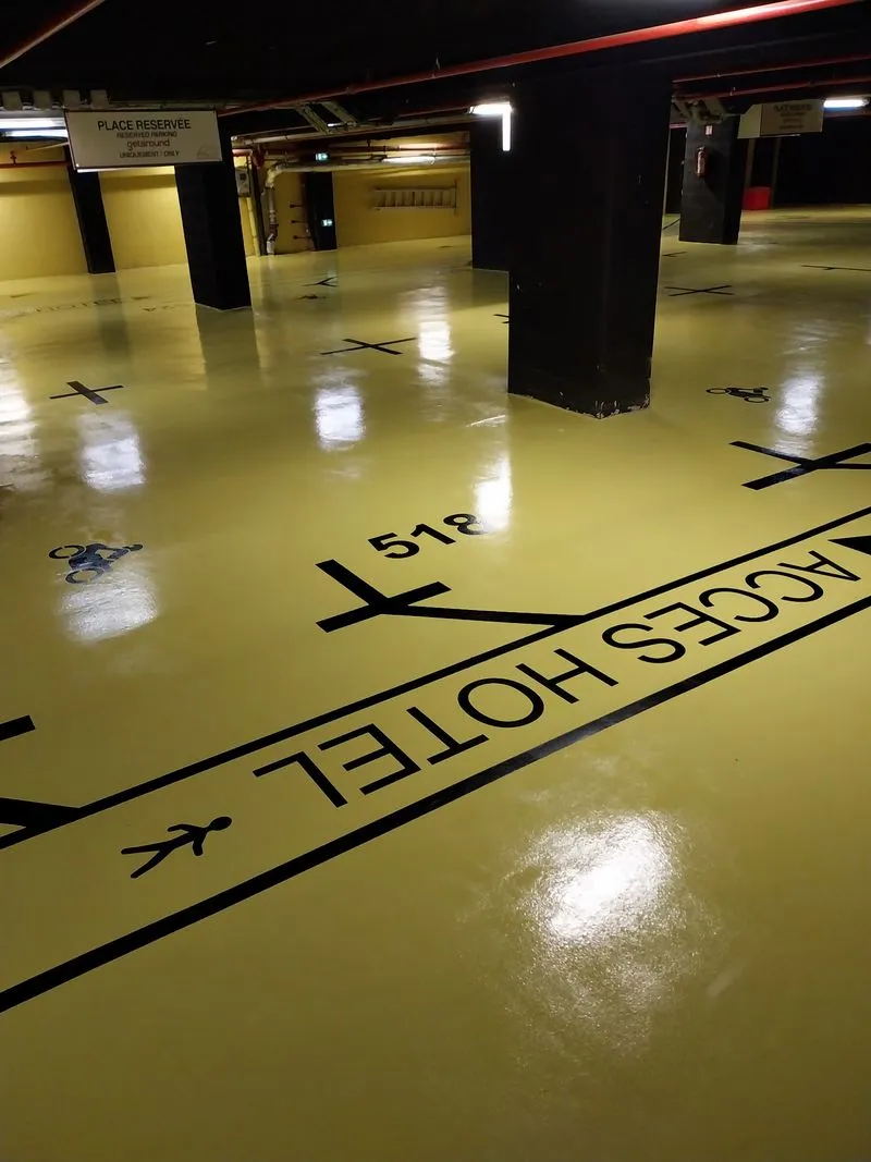 Sol résine et signalétique peinte dans un parking d’hôtel