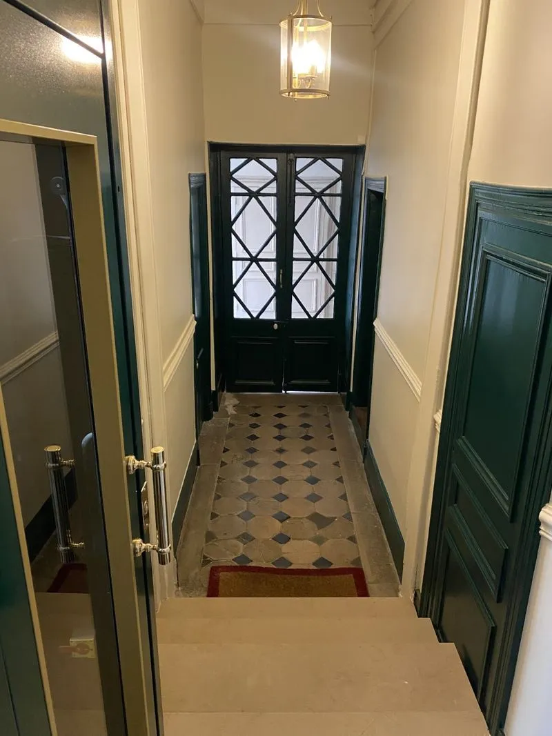 Couloir d’entrée d’immeuble avec carrelage ancien et portes vertes, rue Le Regrattier, Paris 4e