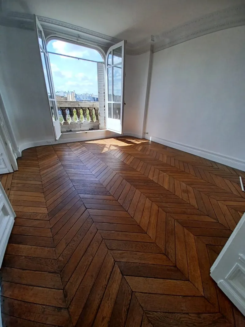 Salon repeint, parquet en chevrons et porte-fenêtre sur balcon, Paris 3e