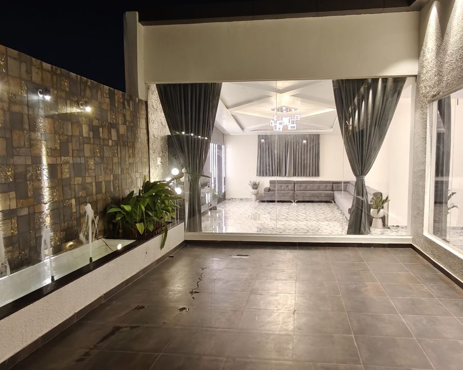 Rooftop terrace opening into the penthouse living room at night in Thanisandra