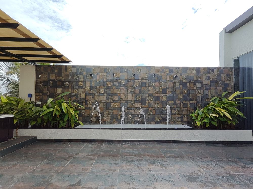 Rooftop deck with a stone water wall and pergola, private party terrace in Thanisandra