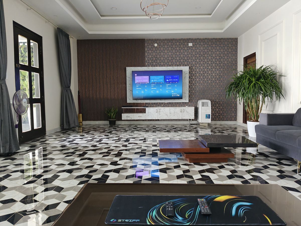 Nimbus 2BHK penthouse living room with sofa, TV wall and patterned marble floor