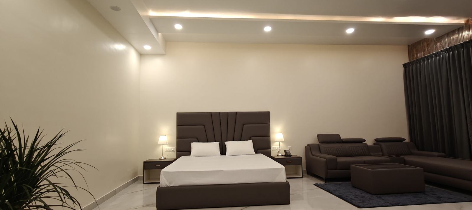 Hotel room with a double bed and sofa seating at Yello Stays Manyata, Thanisandra