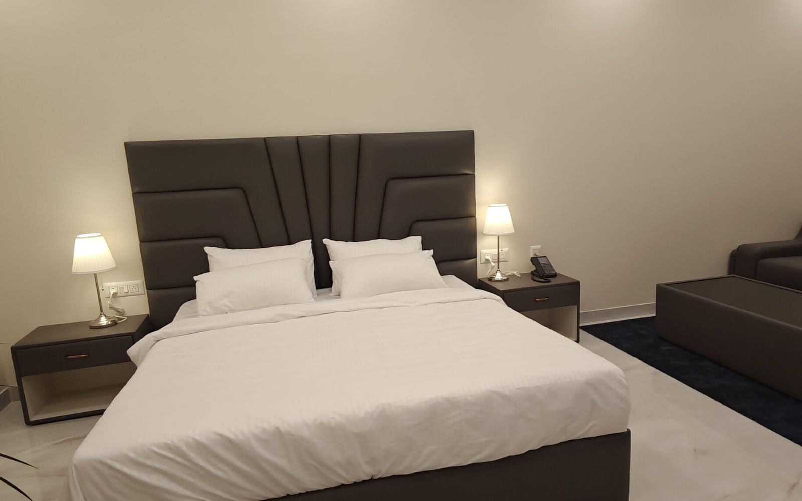 Deluxe Room with a double bed, sofa and marble floor at Yello Stays Manyata on Thanisandra Main Road