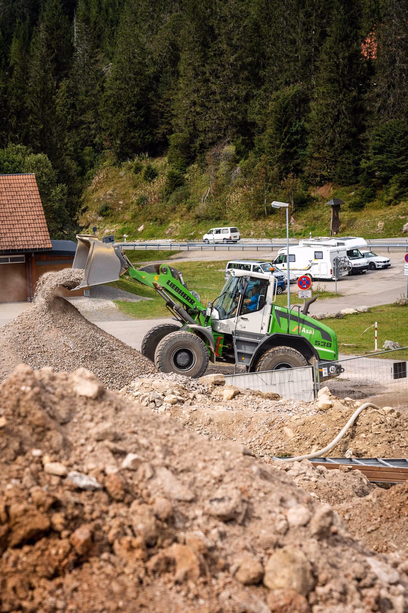 Radlader schüttet Kies auf großen Haufen auf einem Lagerplatz