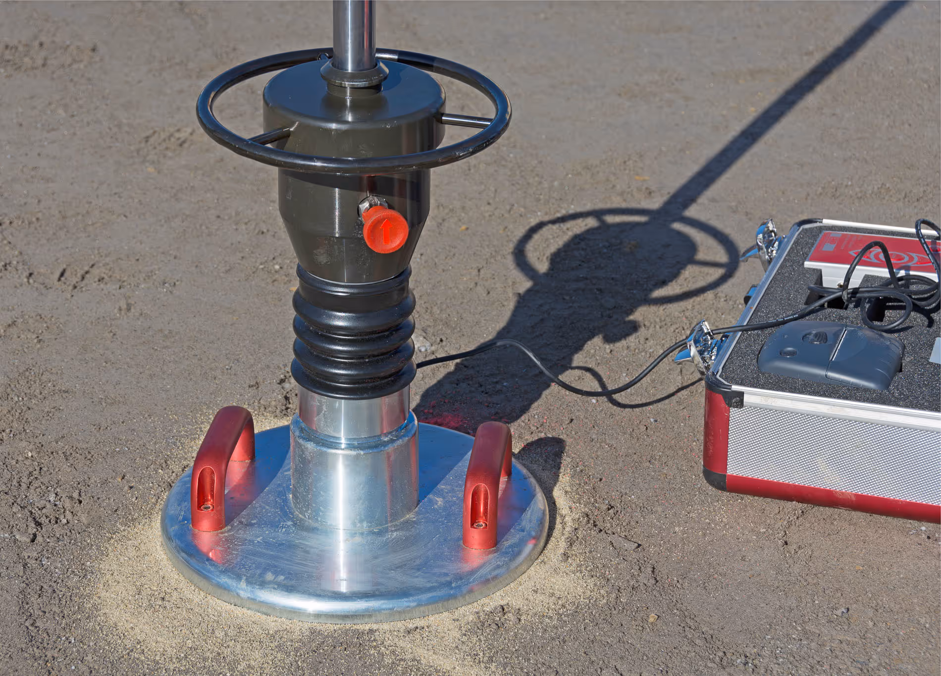 Prüfgerät und Betonwürfel bei der Qualitätskontrolle auf einer Baustelle.