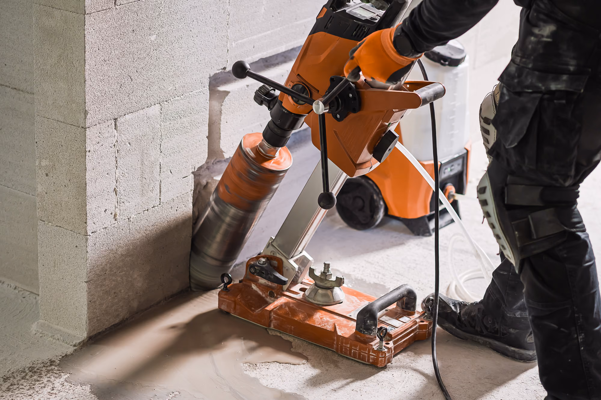 Baustellenmitarbeiter führt auf einer Baustelle einen Frischbeton-Konsistenztest mit einem Kegelgerät durch.