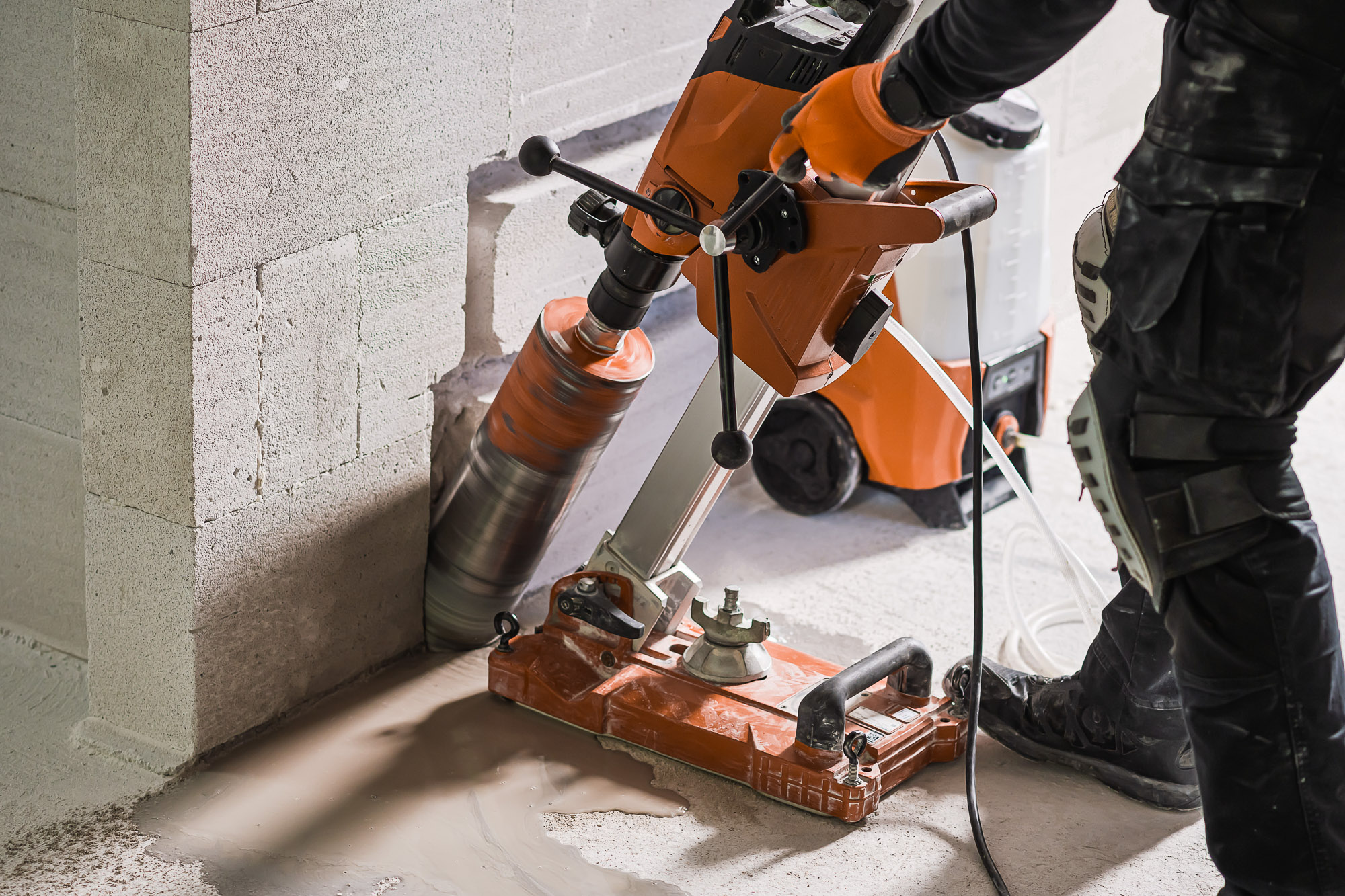 Baustellenmitarbeiter führt auf einer Baustelle einen Frischbeton-Konsistenztest mit einem Kegelgerät durch.