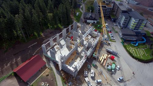 Neubau der "Fundorena" auf dem Feldberg. Baustelle eines Rohbaus im Gebirge mit gelbem Baukran, umgeben von Hotels, Straßen und Parkplätzen.