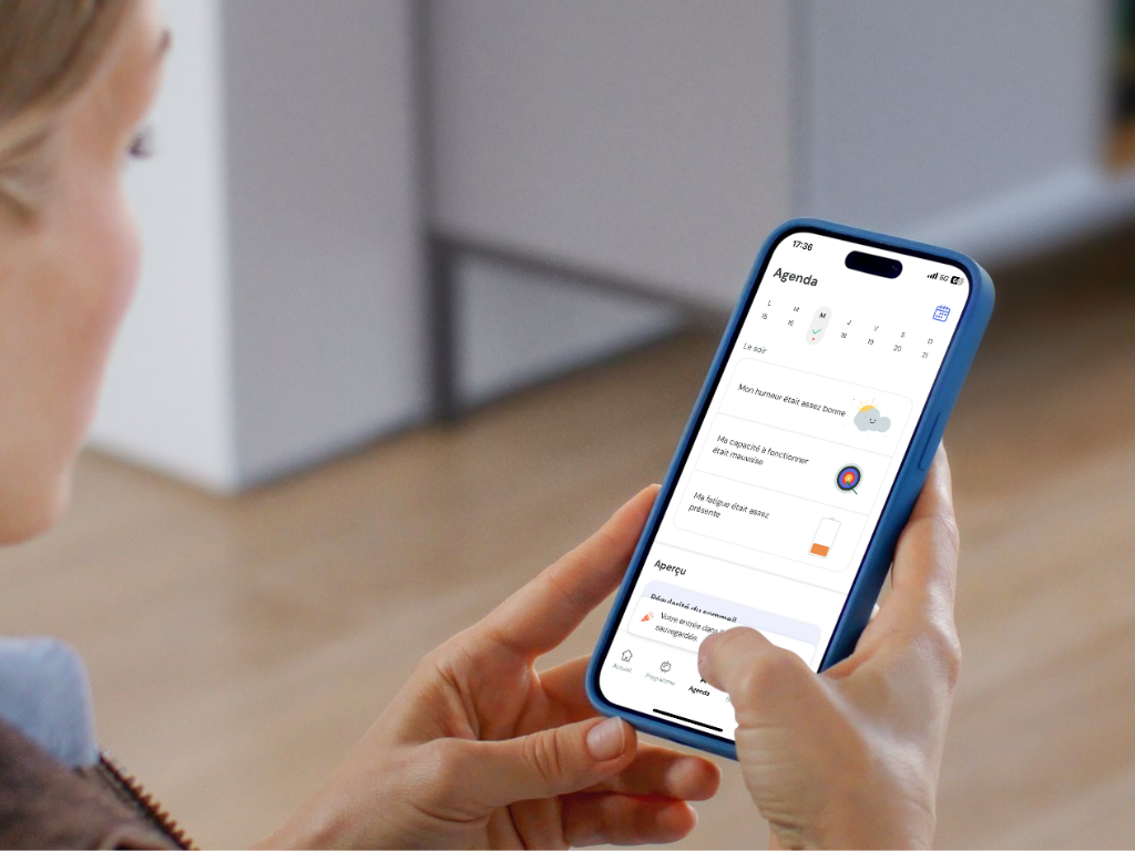 Femme tenant un smartphone avec l'application de thérapie numérique HelloBetter insomnie