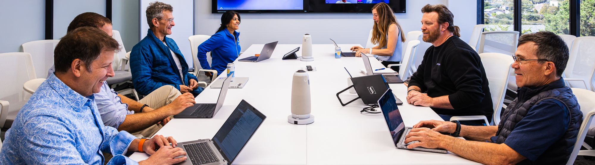 BigHat team in a weekly portfolio meeting around a long conference table