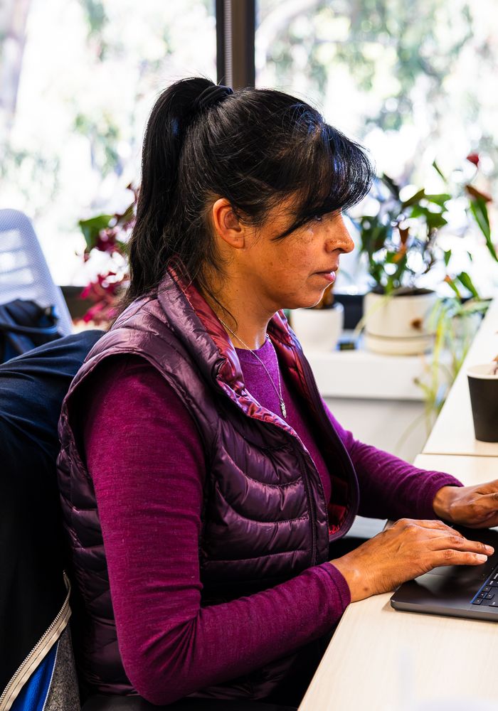 BigHat team member working at a desk surrounded by plants