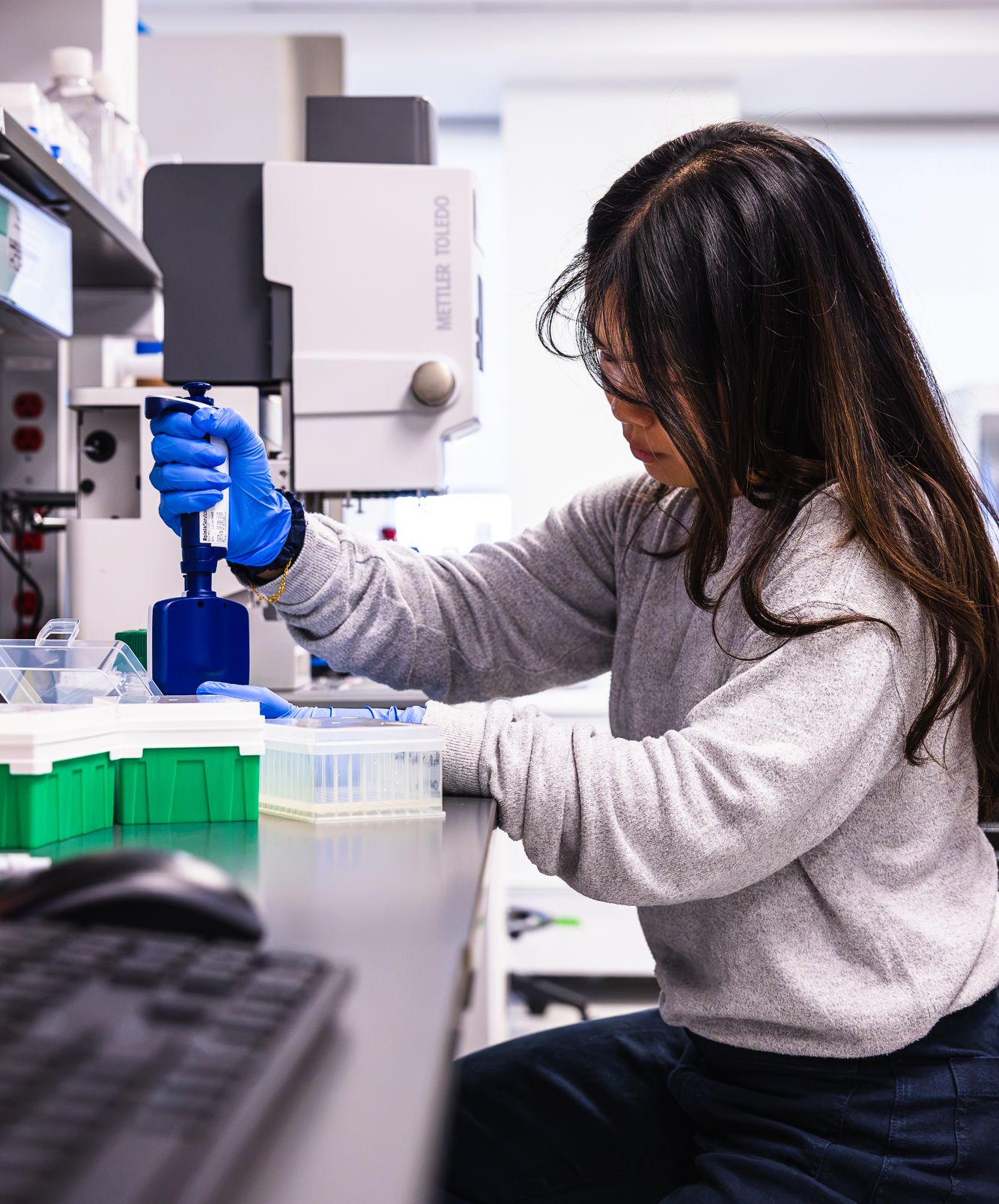 BigHat scientist using a multichannel pipette at the bench
