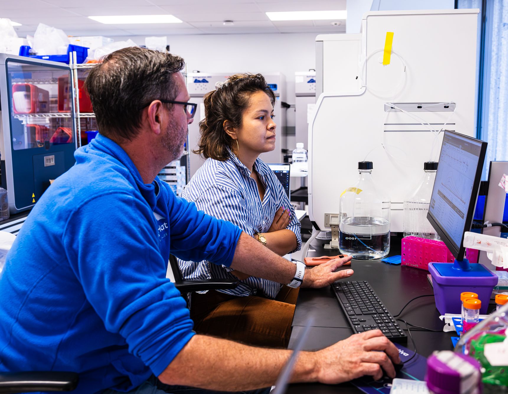 Two BigHat scientists reviewing data at a lab workstation