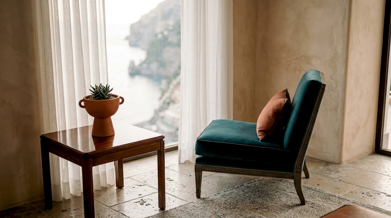 Interior corner featuring terracotta vase and teal armchair