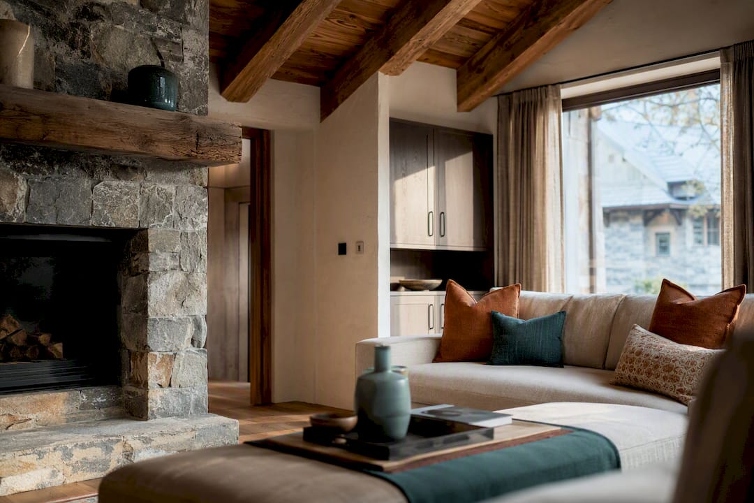Alpine-style interior with timber beams and stone hearth