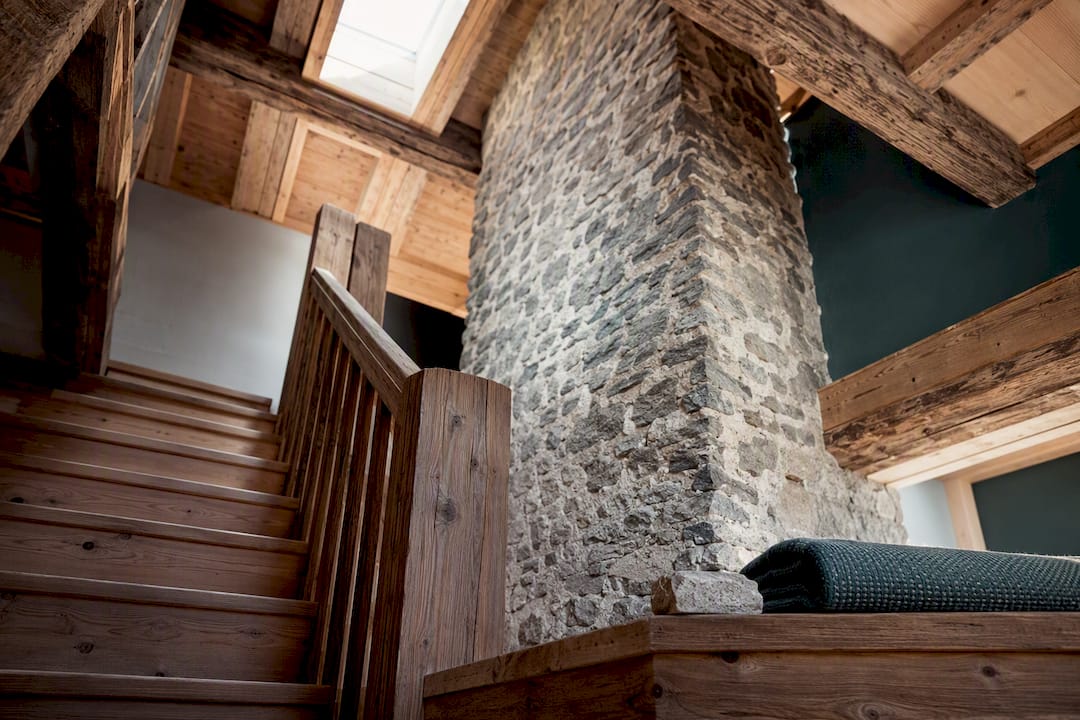 Original chalet beams beside restored stone chimney