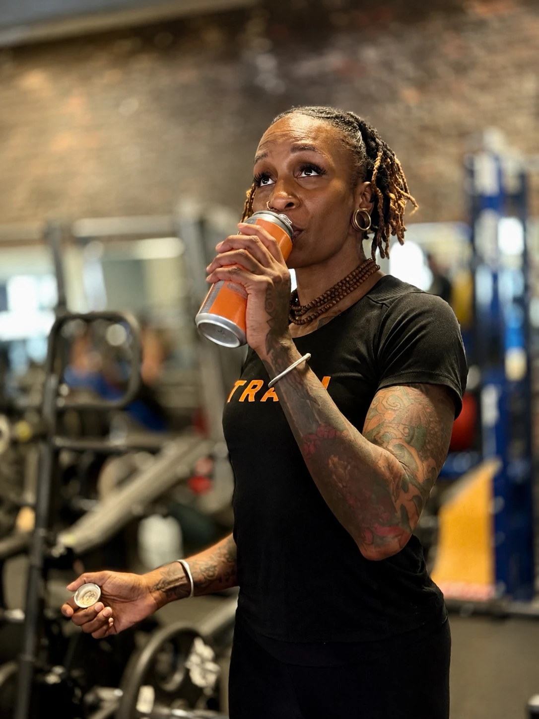 Woman taking a sip of zero sugar tea during a workout