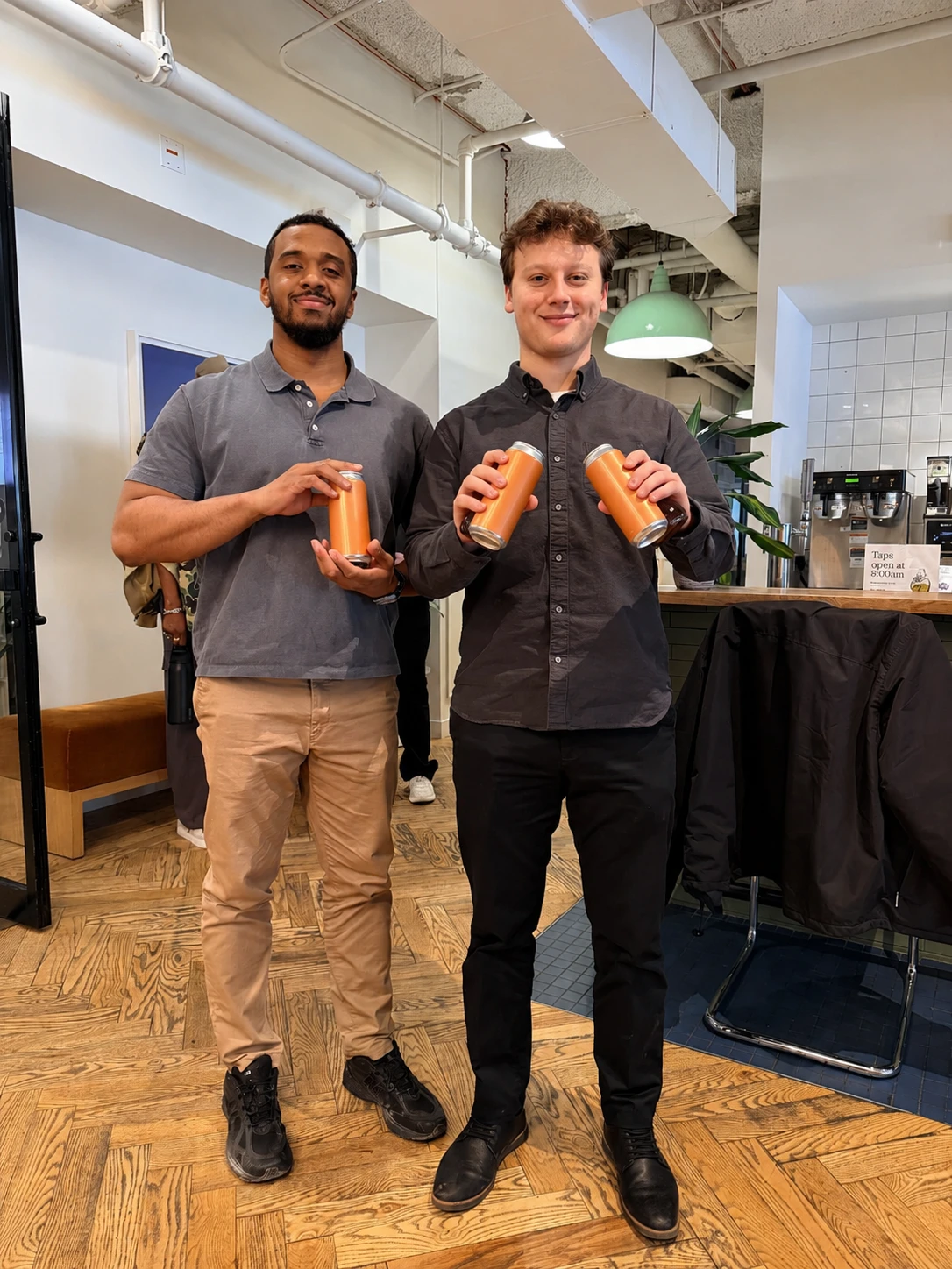 Two coworking-space members holding cans of zero sugar tea