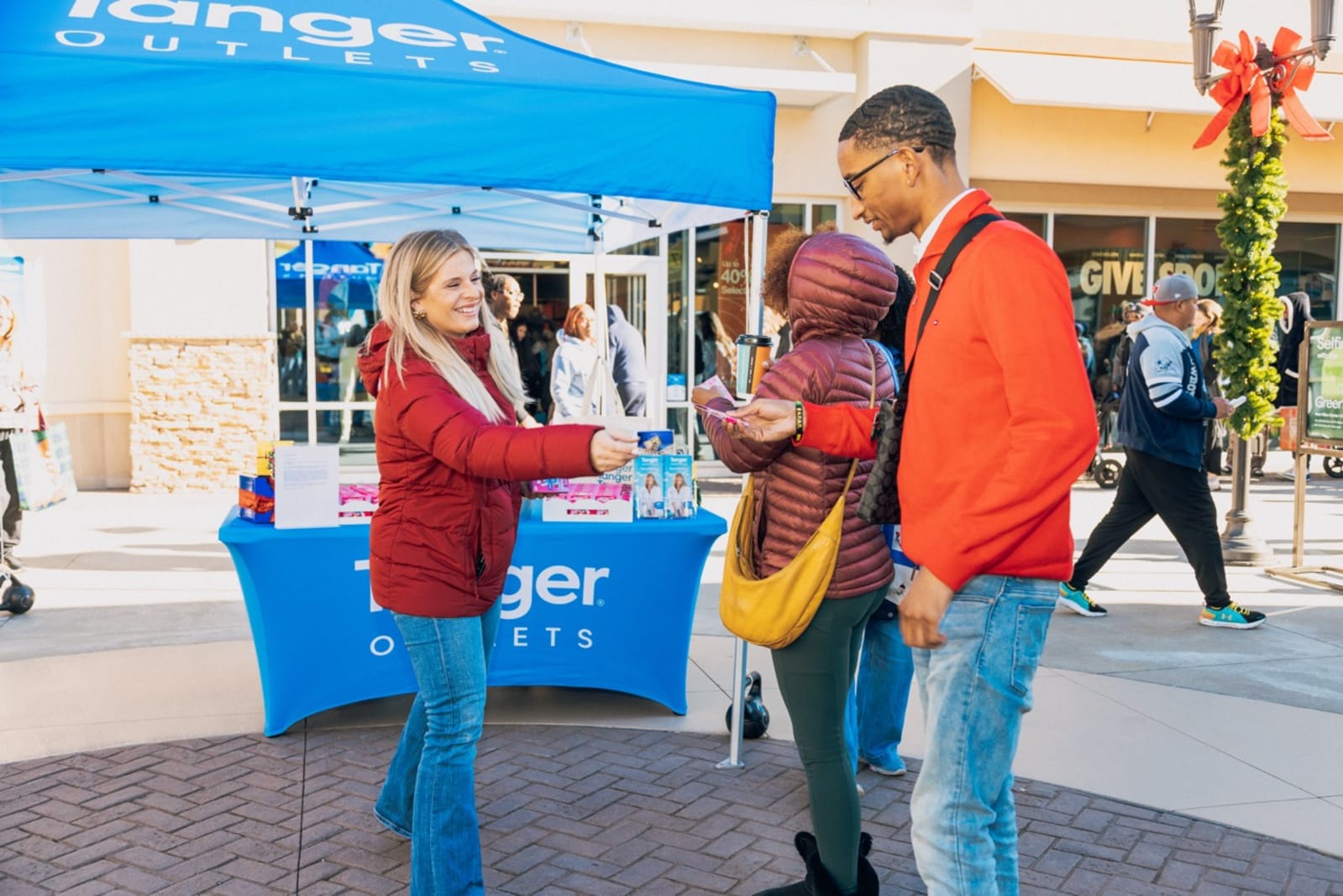 A shopper receives a sample of the chewable tablets at a Tanger Outlets sampling tent