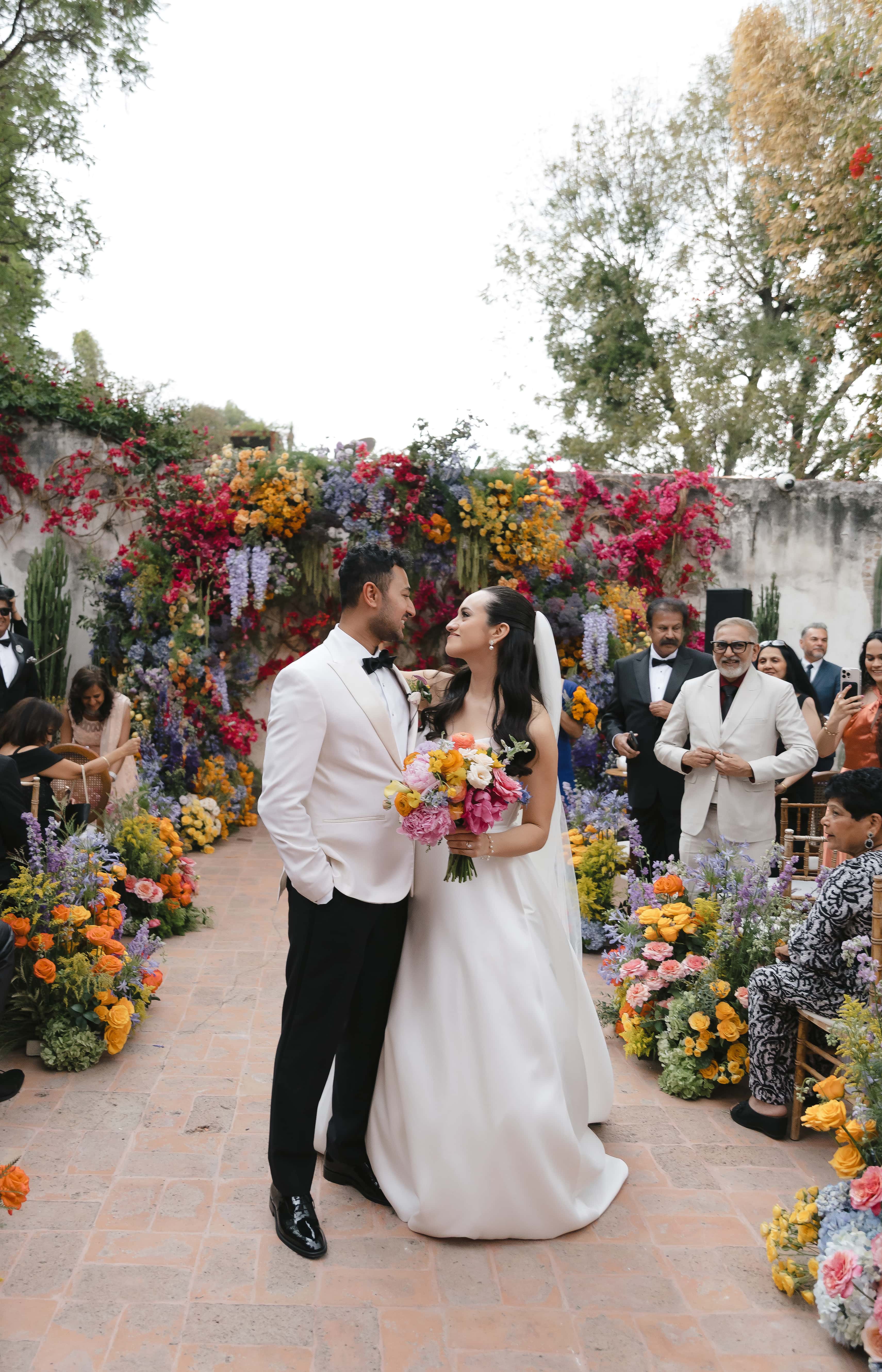 Grooms walking hand in hand through garden path