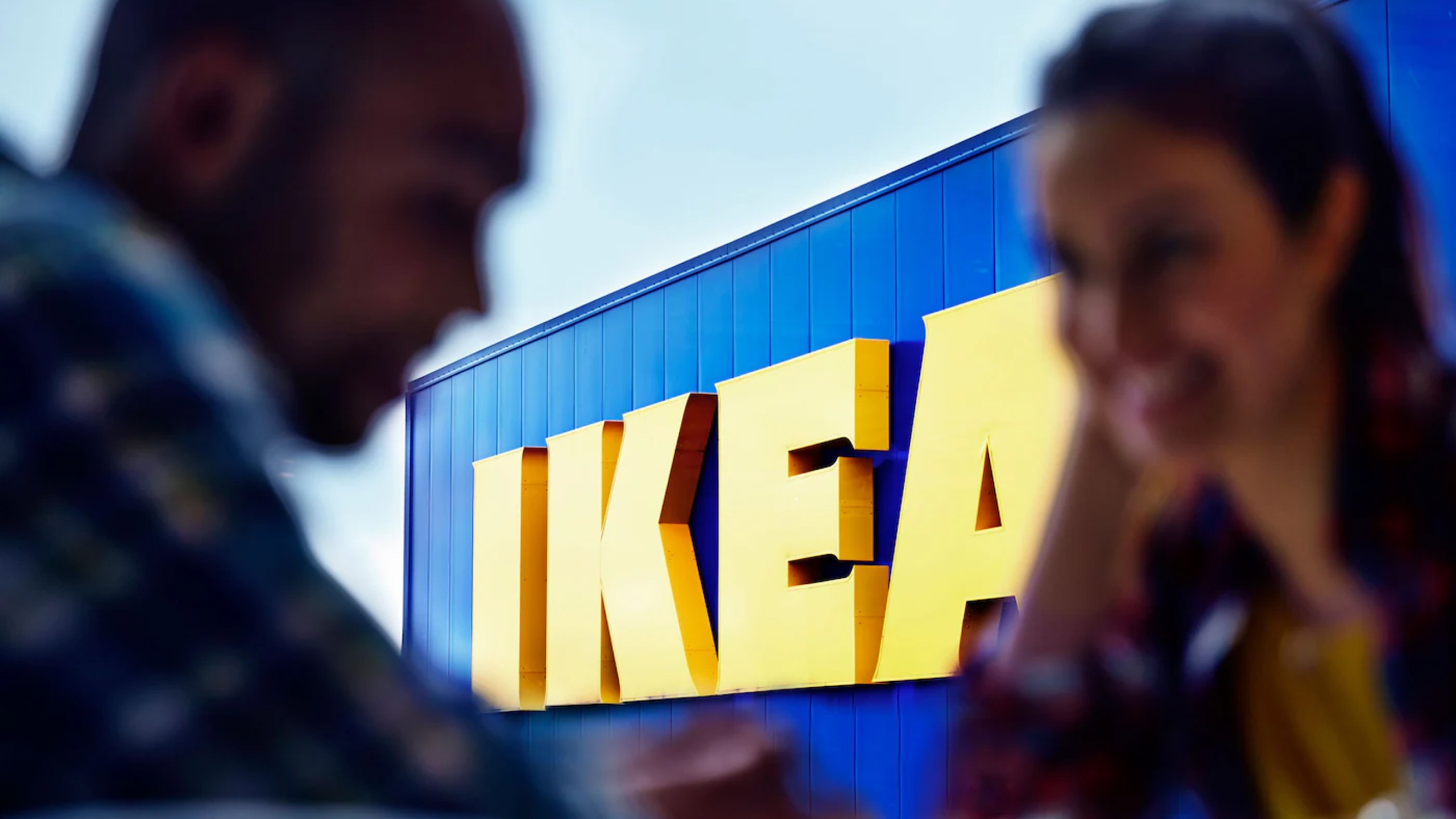 IKEA logo in the background and two advertisers in a meeting in the foreground.