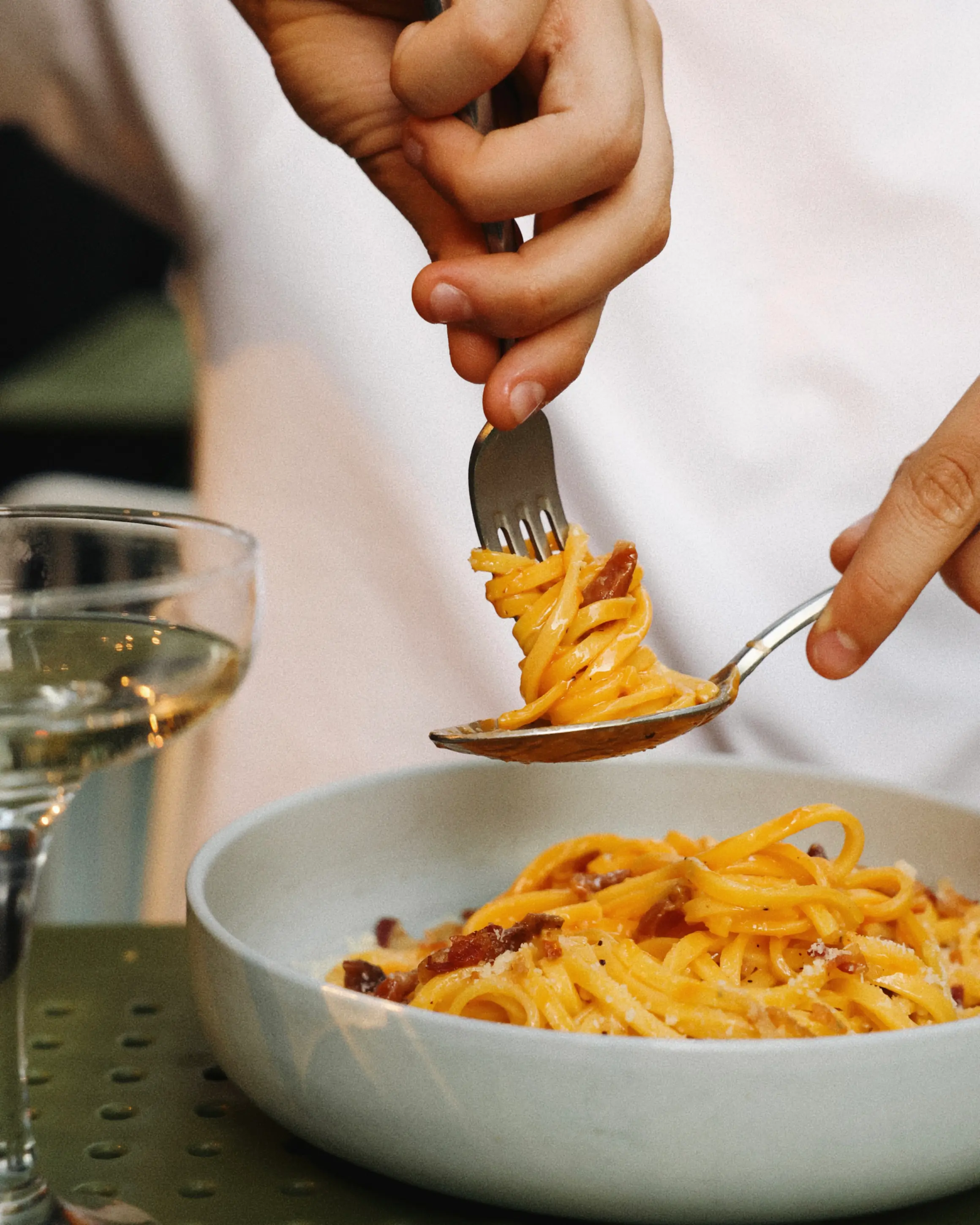 A plate of carbonara twirling round a fork