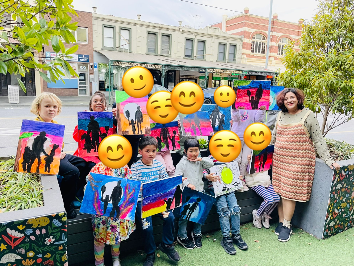 A senior man and a group of smiling kids in paper hats