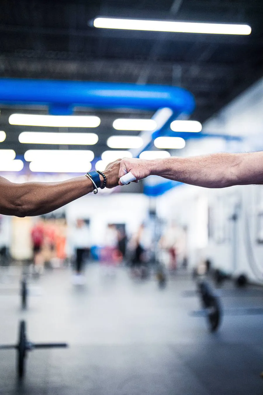 Two members bumping fists on the gym floor