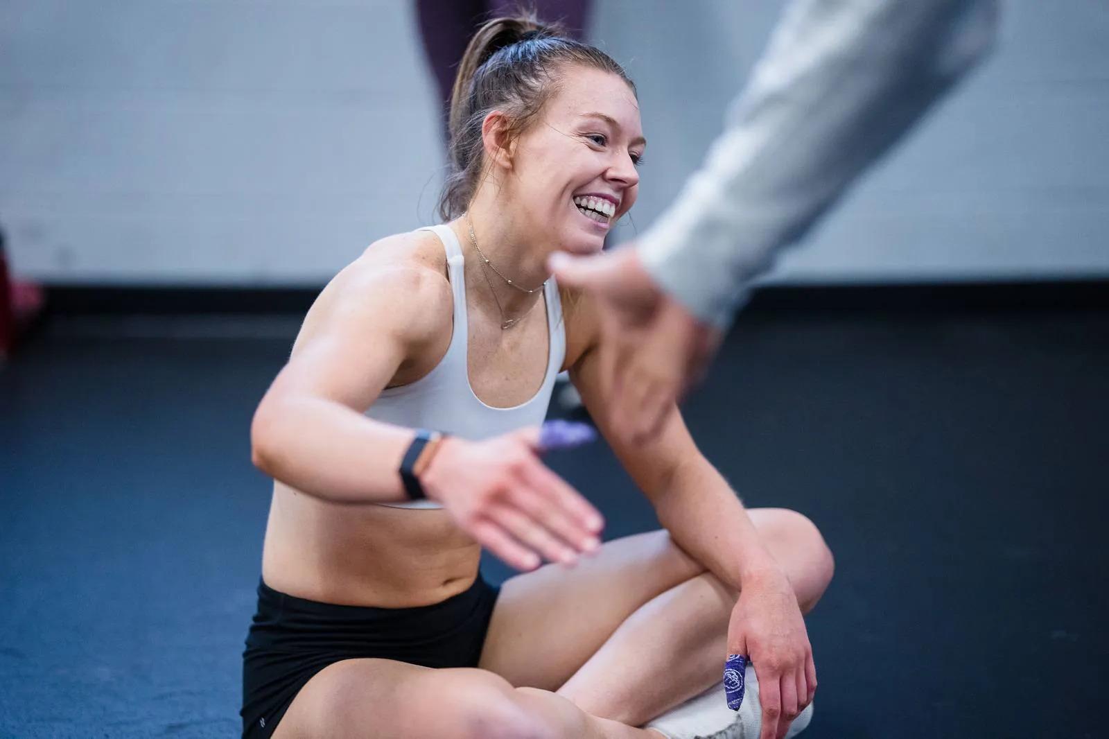 A member laughing with her coach after class