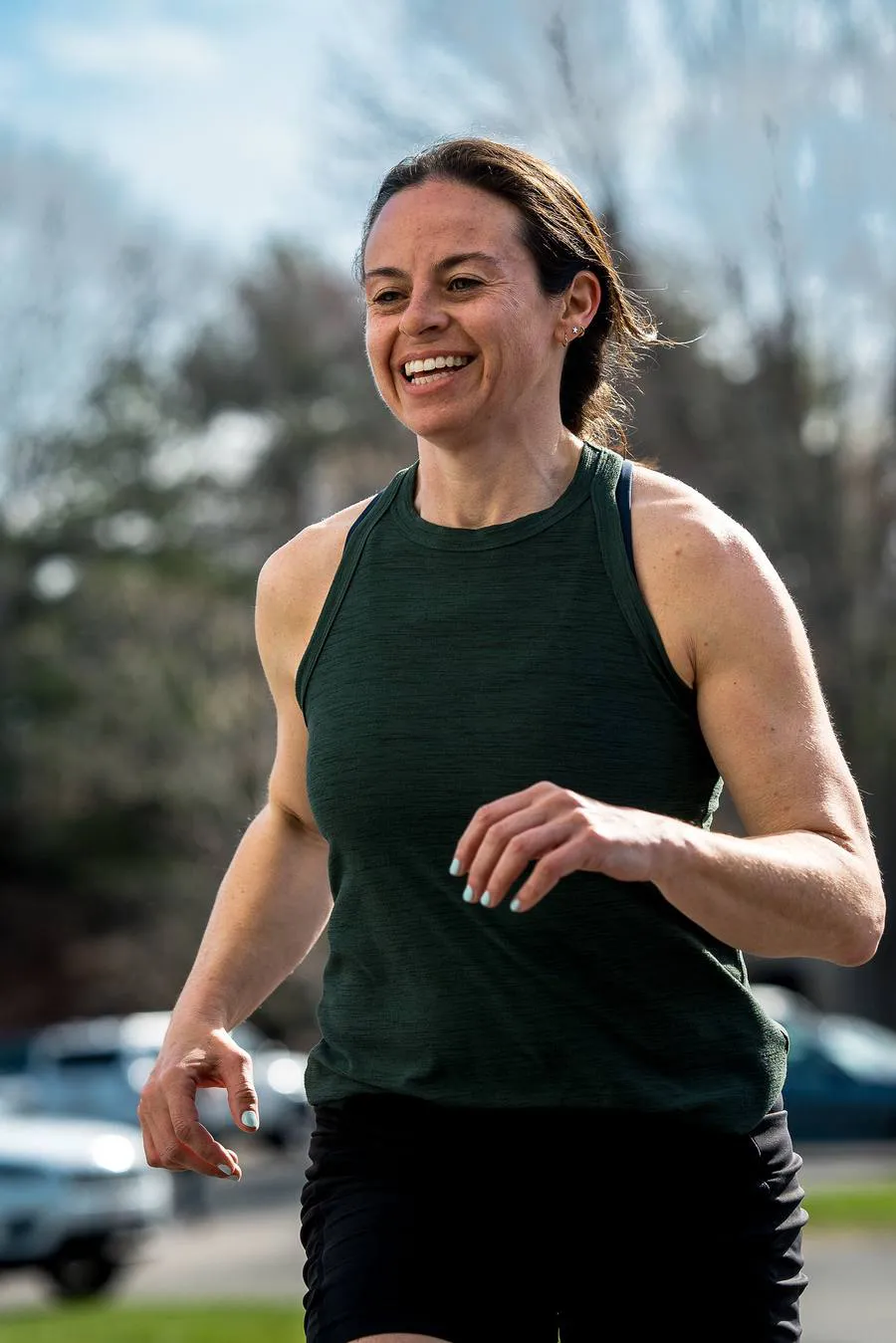 A member smiling mid-run outdoors