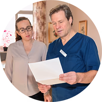 Sjukvårdspersonal diskuterar patientdokument tillsammans inne på sjukhus eller klinik.