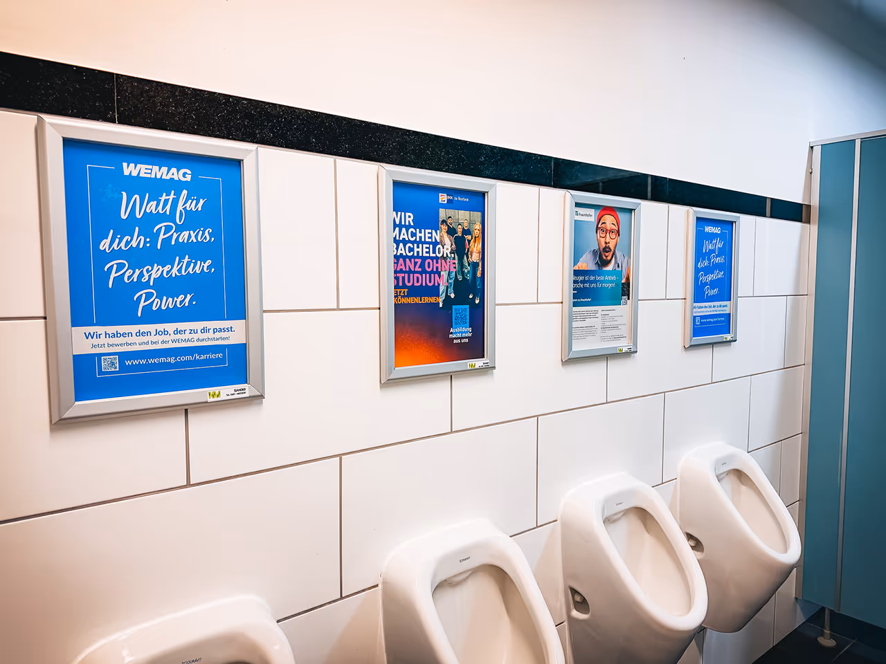 von Novus Marketing gebuchte Werbeplakate im Sanitärbereich an der Universität Rostock.  