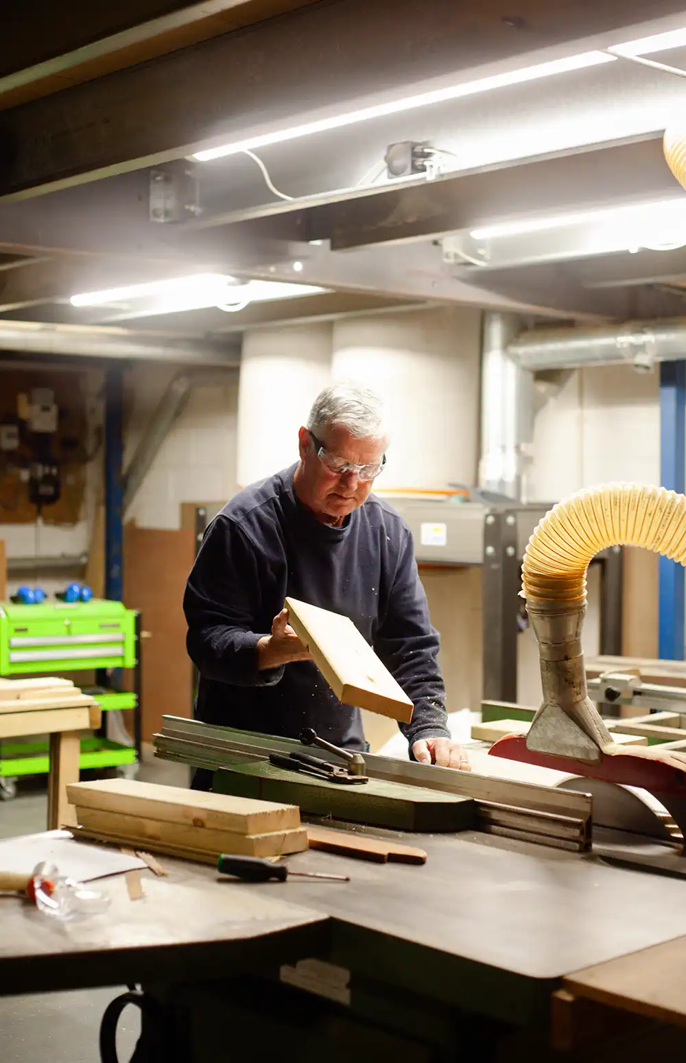 Our Warehouse Assistant inspecting wood being cut on the rip saw