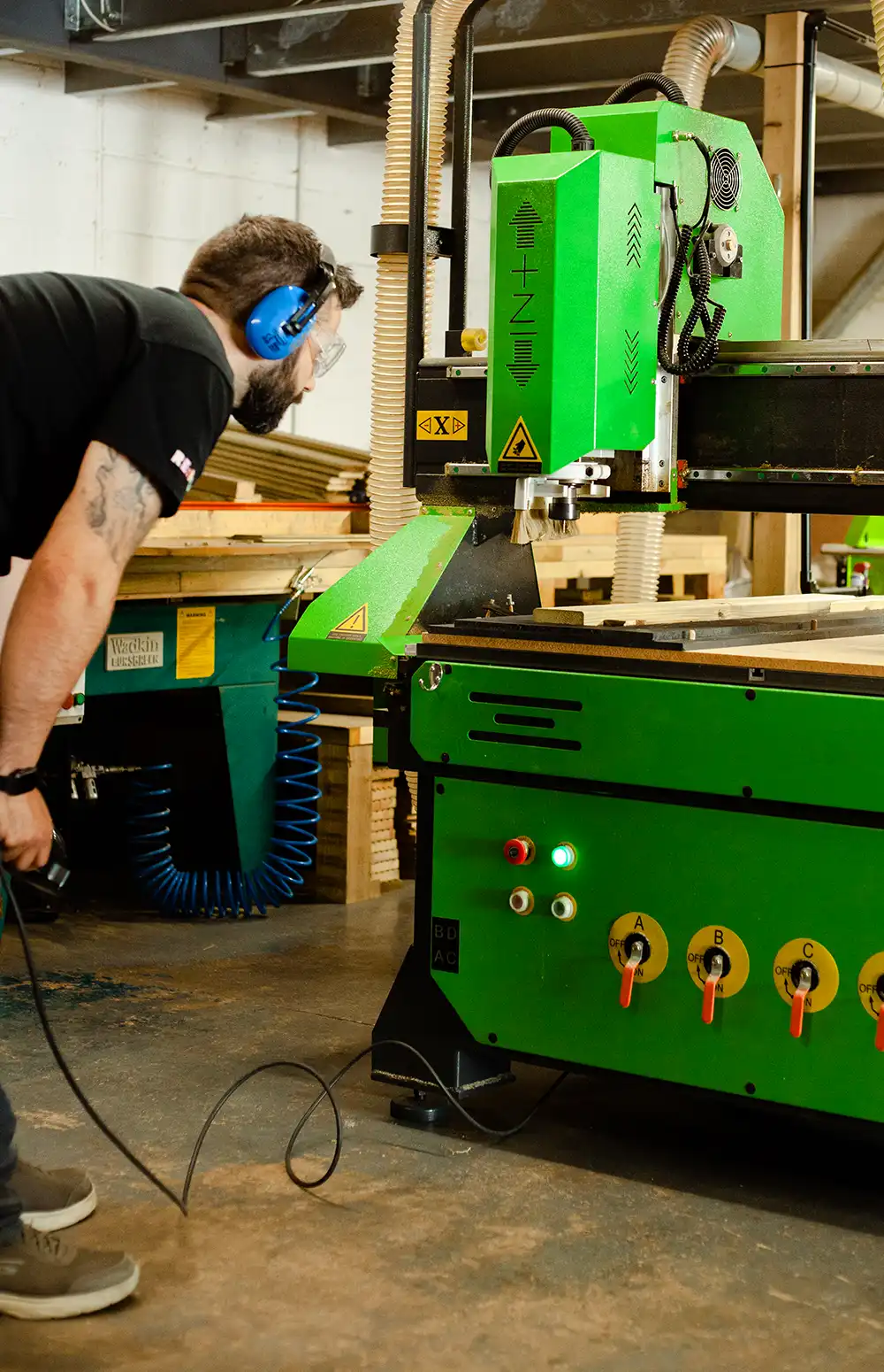 Our Warehouse Manager using our CNC machine to custom cut Scandinavian Redwood
