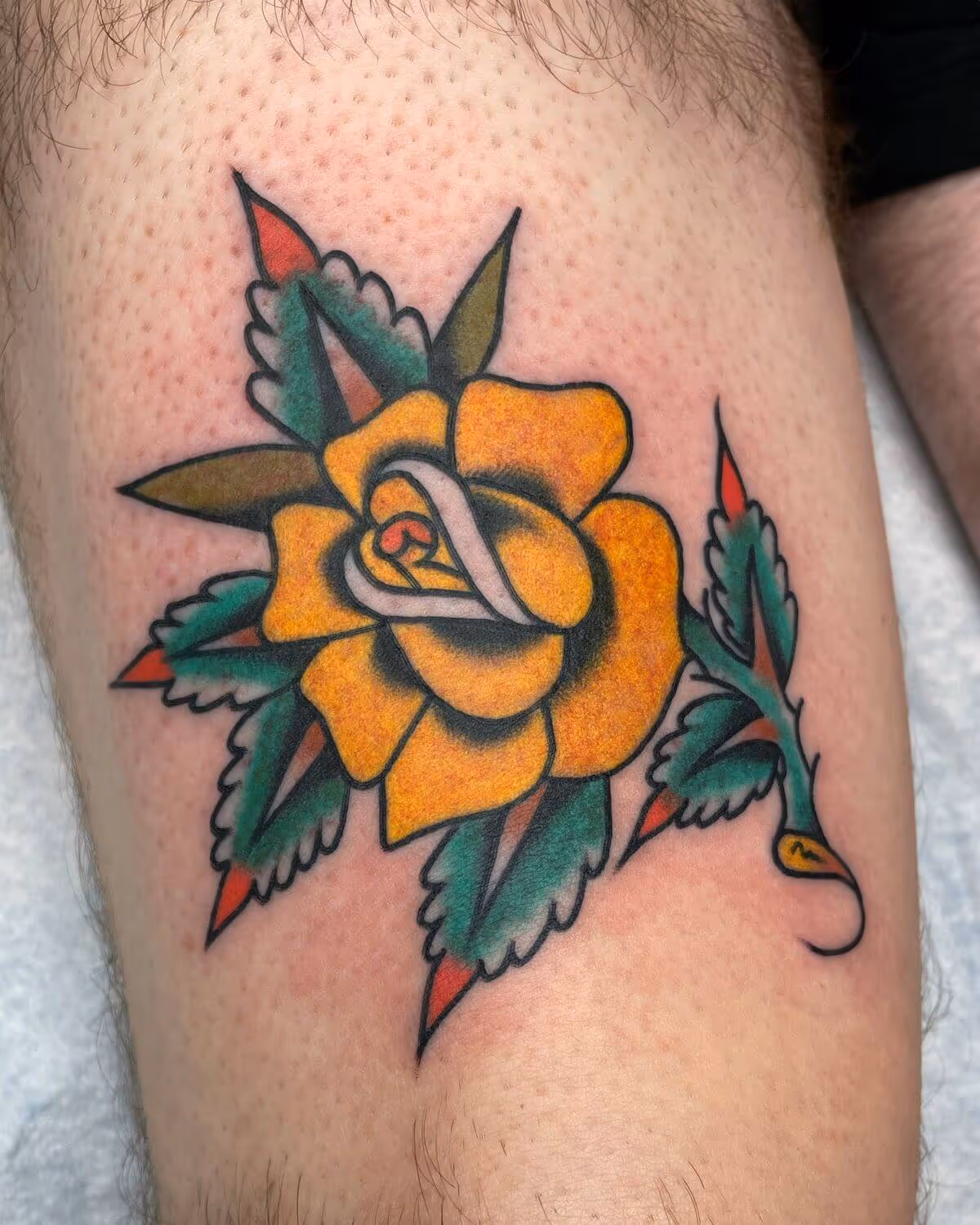 Traditional yellow rose tattooed by Joshua Bighaus.