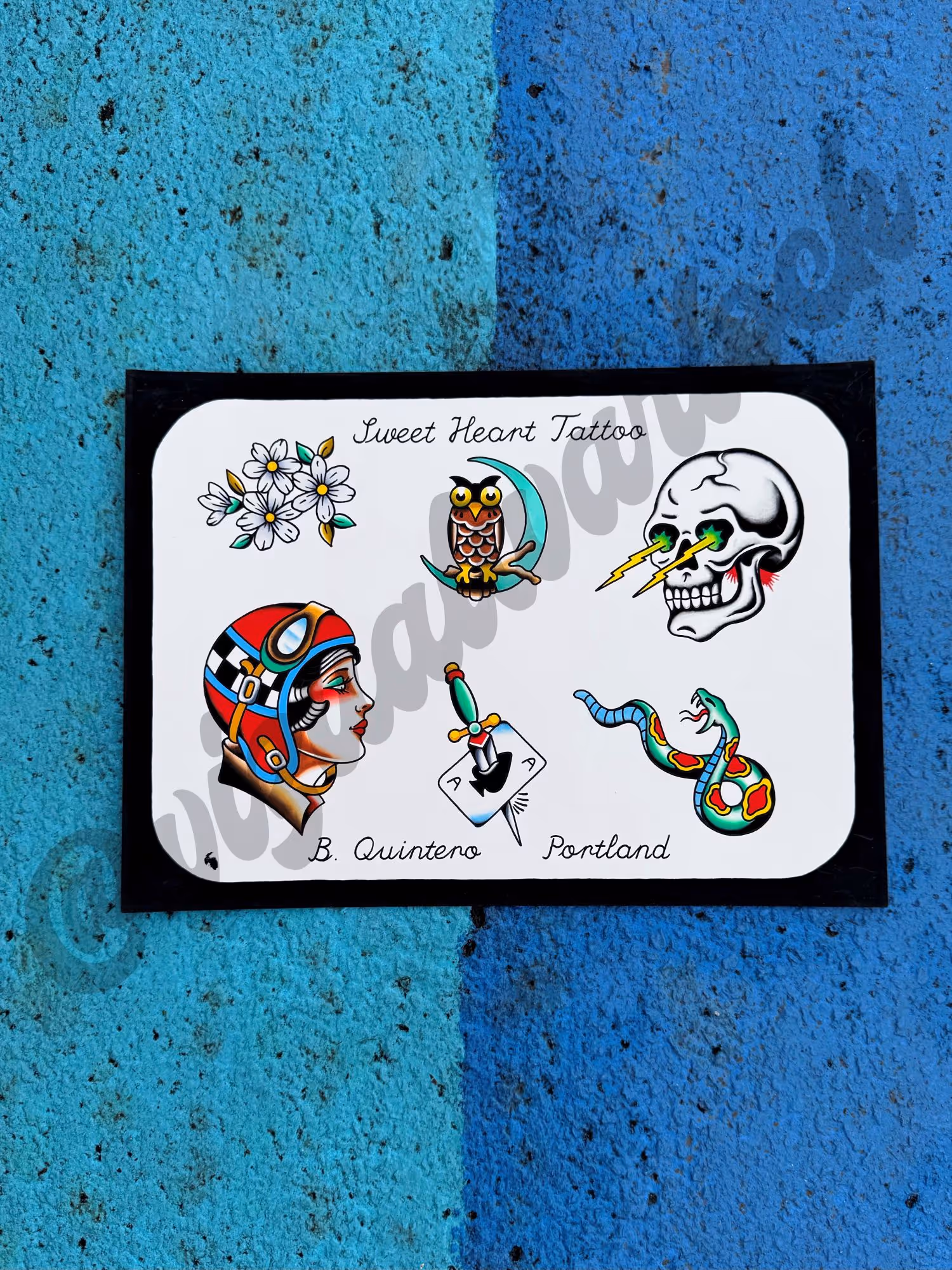 Tattoo flash sheet with designs of flowers, owl on a crescent moon, skull with lightning eyes, woman in helmet, dagger through ace card, and colorful snake on white background.